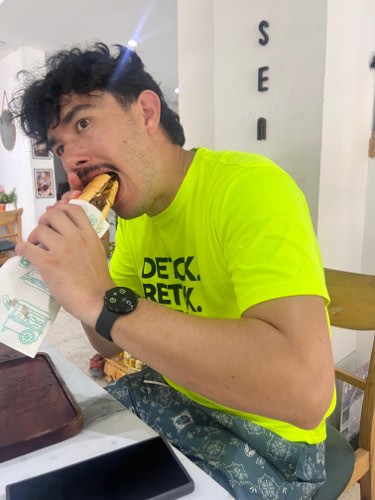 Adrian mid-bite on a sandwich